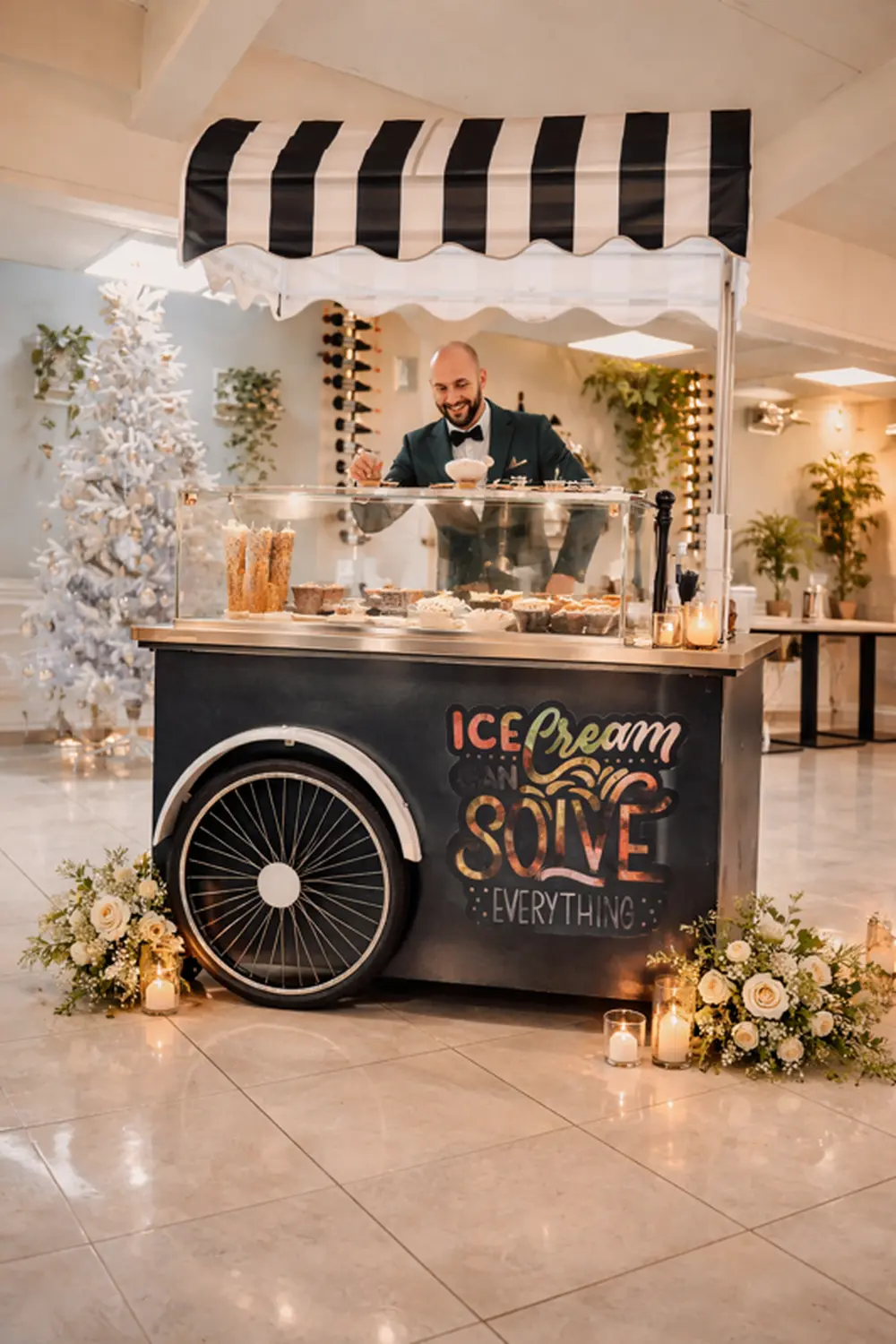 Carretto gelati nero con gelataio, candele e fiori