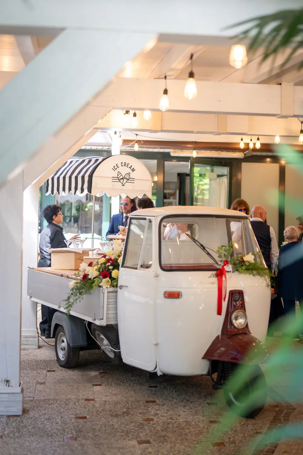 Apecar bianca gelateria addobbata con fiori, lucine