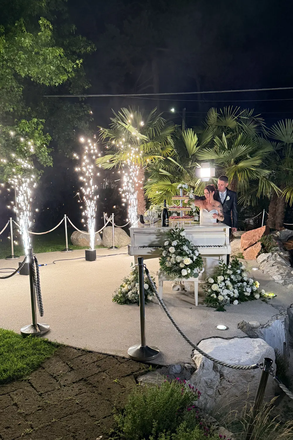 Fontane di scintille e piano fiorito, sposi, notte