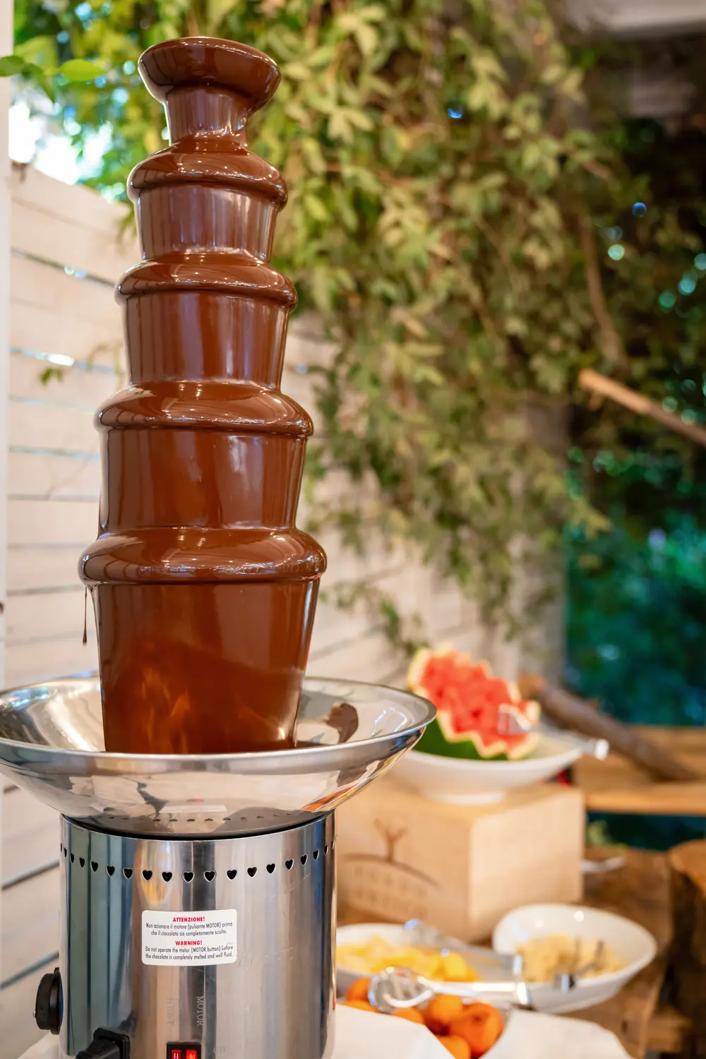 Fontana di cioccolato a cascata, frutta accanto