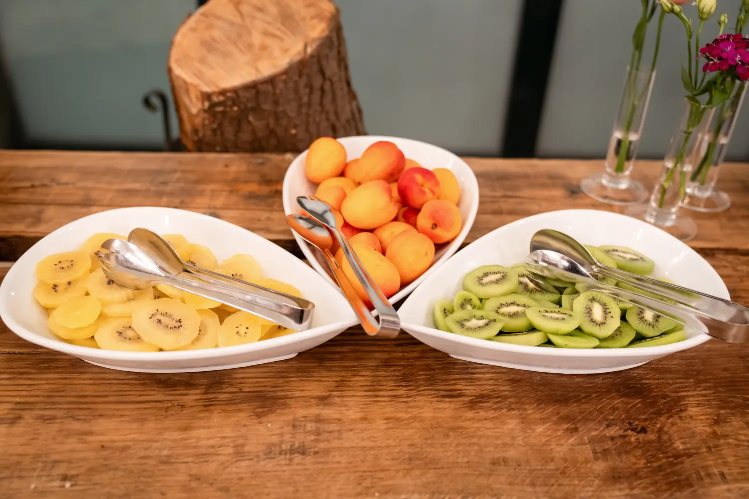 Tre ciotole di frutta tagliata, kiwi e albicocche