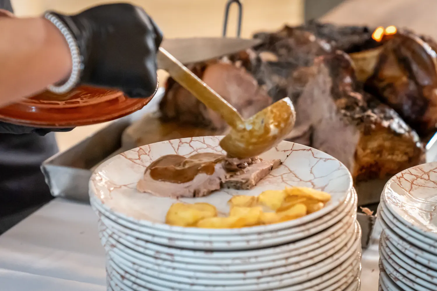 Colata di salsa sul piatto, arrosto sfocato dietro