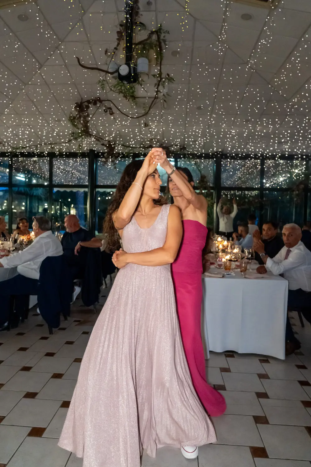Due invitate ballano, lucine e tavoli